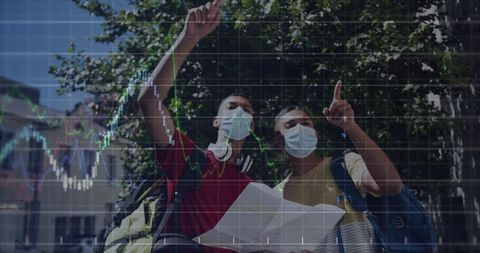 Masked travelers pointing at map with financial chart overlay in urban plaza