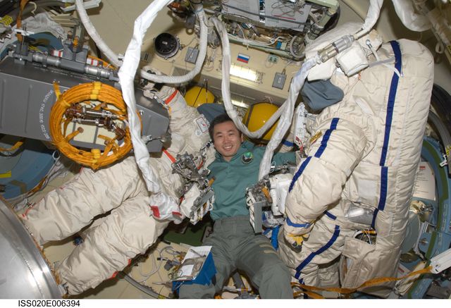 ISS020-E-006394 (4 June 2009) --- Japan Aerospace Exploration Agency (JAXA) astronaut Koichi Wakata, Expedition 20 flight engineer, is pictured between two Russian Orlan spacesuits in the Pirs Docking Compartment of the International Space Station.