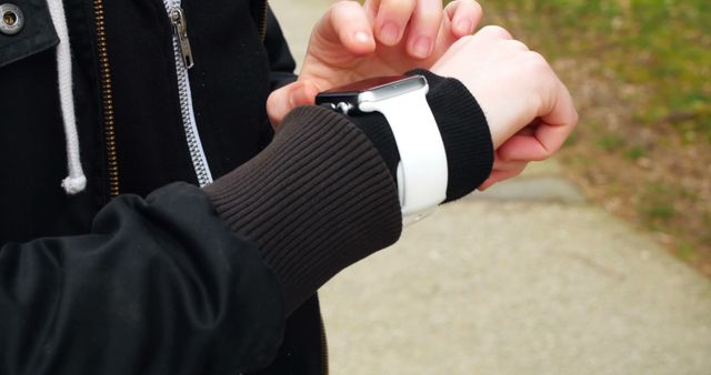 A person is checking a smartwatch while outdoors, with copy space - Download Free Stock Photos Pikwizard.com