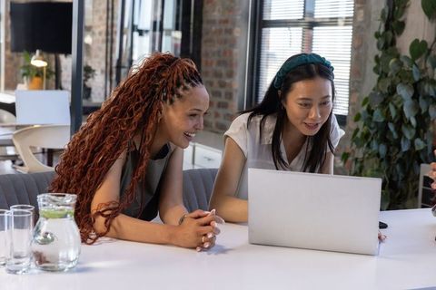 Diverse female coworkers collaborating at modern office
