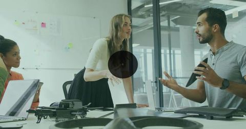 Female project lead directing team in modern office discussing drone design and innovation