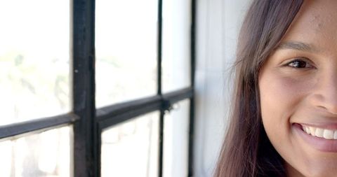 Smiling Woman Enjoying Natural Light by Office Window