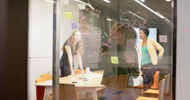 Businesswomen Brainstorming Ideas on Glass Wall in Modern Office - Download Free Stock Images Pikwizard.com