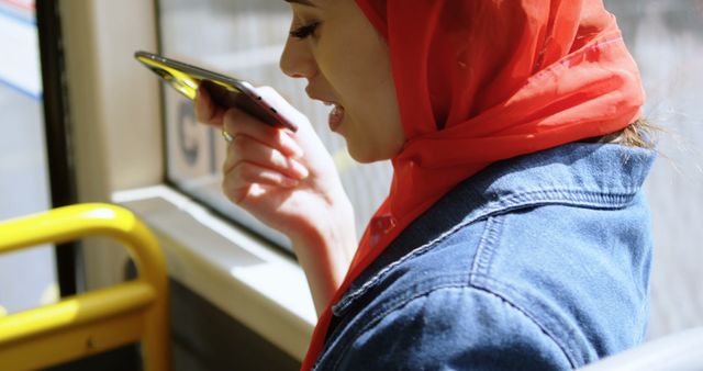 Muslim Woman in Red Hijab Using Smartphone Voice Assistant on Bus - Download Free Stock Images Pikwizard.com