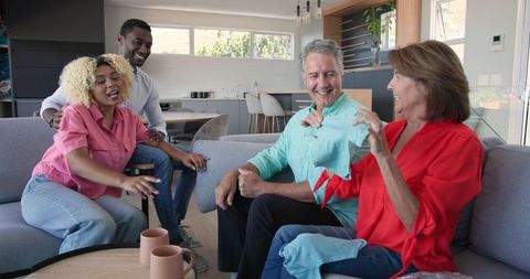 Senior Couple and Friends Sharing Joyful Moment with High Fives at Home