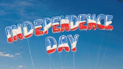 Floating metallic balloons celebrating independence day against blue sky