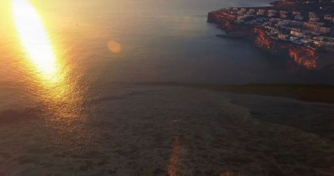 Sunset Over Ocean Cliffs With Vibrant Reflection