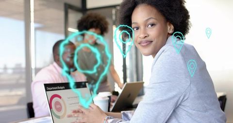 Businesswoman using laptop during team budget meeting with augmented reality icons