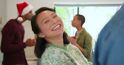 Smiling Friends Enjoy Merry Holiday Gathering in Warm Kitchen