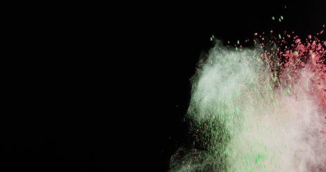 This image depicts a vibrant powder explosion with green, red, and white particles against a stark black background. Ideal for use in festival promotions, digital art projects, creative advertising campaigns, and designs needing a dynamic abstract element. It evokes a sense of celebration and energy.