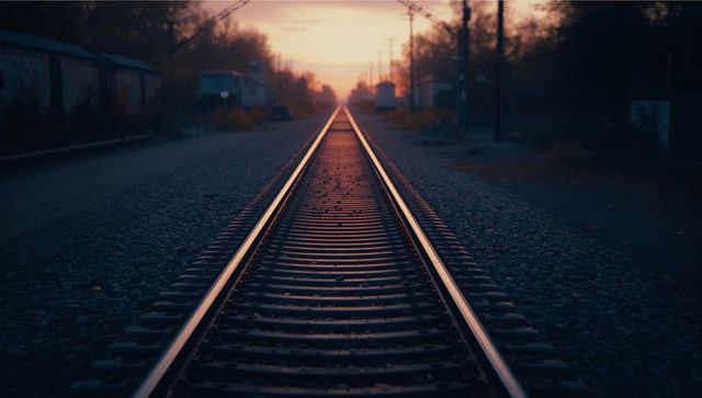 Railway tracks stretching toward sunset horizon
