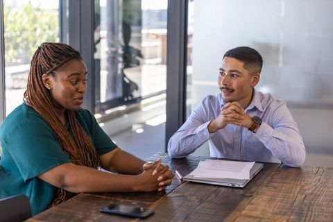 Diverse coworkers discussing project around conference table