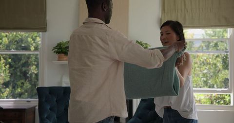 Couple Folding Blanket Together at Home