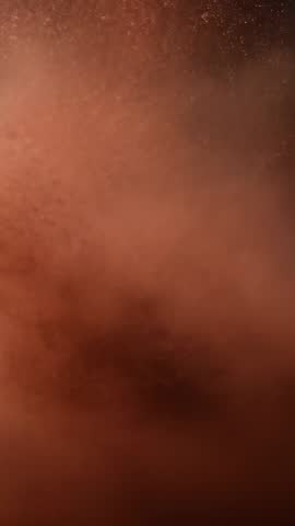 Vertical powder burst expanding with golden sparkles scattering in slow motion