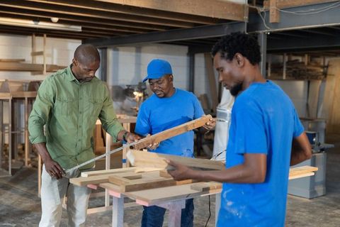 African american men measuring wooden planks workshop, carpentry teamwork and craftsmanship