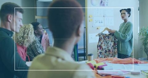 Fashion designer presenting floral dress in creative studio meeting