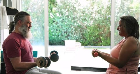 Senior couple bonding over home exercise with garden view