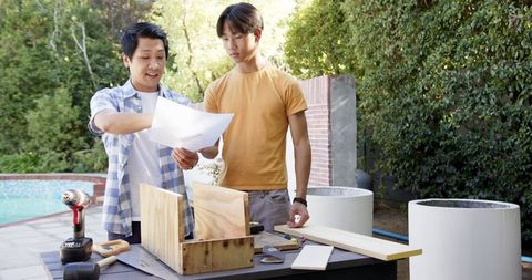 Father and Son Teamwork on DIY Project Near Pool