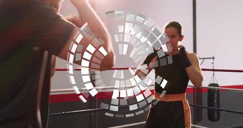 Female boxer training with coach in ring showing focus power and athletic intensity