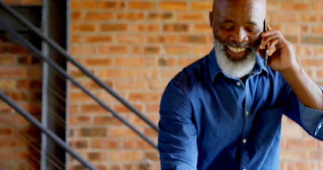 Smiling Man with Beard Talking on Phone Indoors - Download Free Stock Images Pikwizard.com