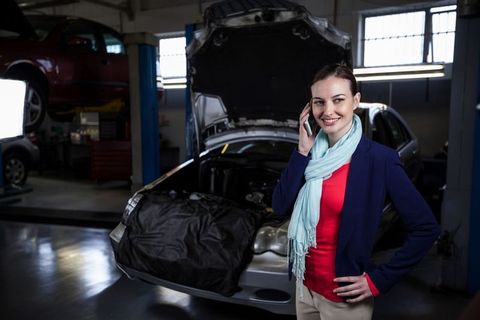 Professional Woman Using Smartphone in Auto Repair Workshop