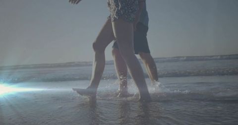 Couple walking barefoot along tranquil beach shore