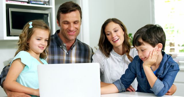 Happy family of four bonding while using laptop at home - Download Free Stock Images Pikwizard.com