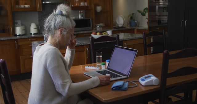 Senior Woman Using Laptop at Home Kitchen Table for Online Communication - Download Free Stock Images Pikwizard.com