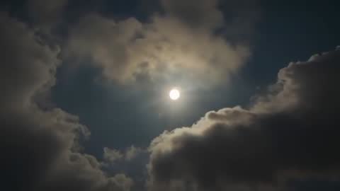 Sun Breaks Through Moving Cumulus Clouds in Sky