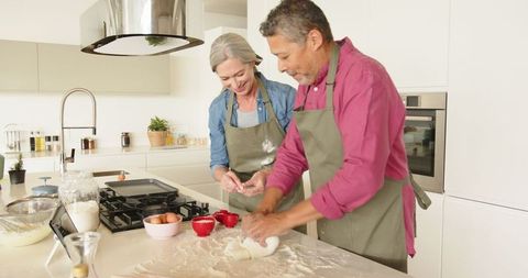 Senior couple baking together at home in modern kitchen