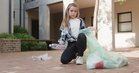 Young Girl Collecting Plastic Waste Outdoors Promoting Environmental Conservation