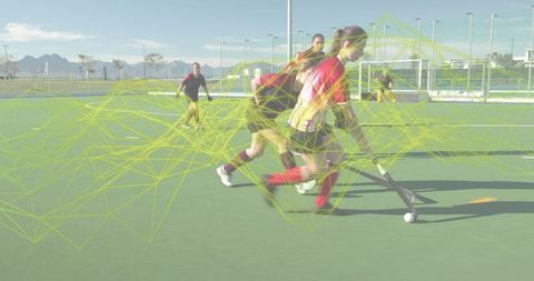 Female field hockey players dribbling with dynamic wireframe overlay on outdoor turf