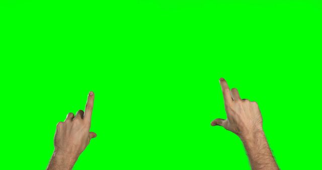Two Caucasian hands are gesturing against a green screen background, with copy space. The hands appear to be interacting with or pointing at virtual elements that could be added during post-production.