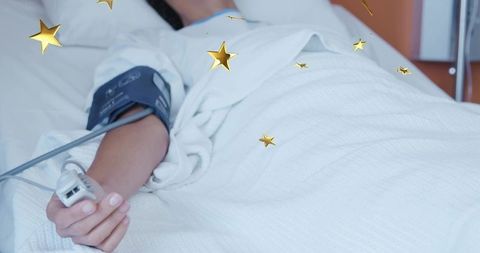 Female patient lying in hospital bed with blood pressure cuff and pulse oximeter