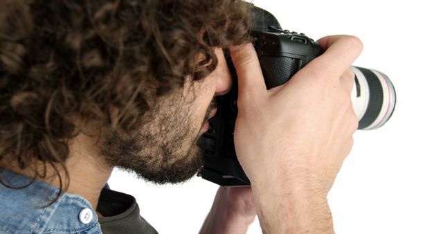 Photographer with curly hair using DSLR camera on white background - Download Free Stock Images Pikwizard.com