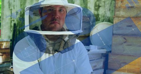 Beekeeper in apiary yard with wooden hives and mesh veil