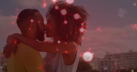 Romantic couple kissing on rooftop terrace at sunset