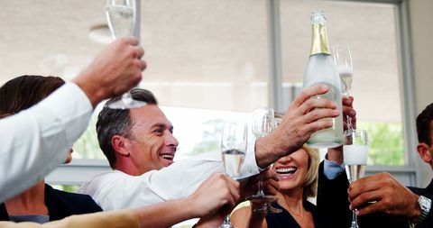 Smiling Friends Toasting with Champagne Glasses in Restaurant