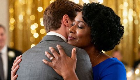 Mother and Son Embracing on Ballroom Dance Floor at Elegant Reception with Golden Bokeh