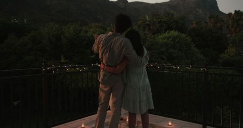 Couple Embracing on Balcony During Tranquil Sunset