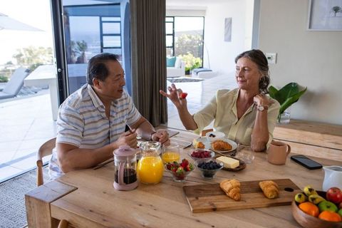 Senior couple enjoy relaxed breakfast at home with juice and pastries