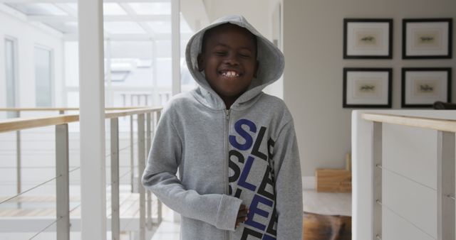Portrait of happy african american boy wearing hoodie smiling at home. Lifestyle, childhood and domestic life, unaltered.