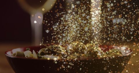 Festive golden bokeh over wine glass and appetizers
