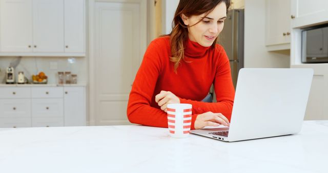 Young Woman Working on Laptop in Modern Kitchen with Coffee Mug - Download Free Stock Images Pikwizard.com