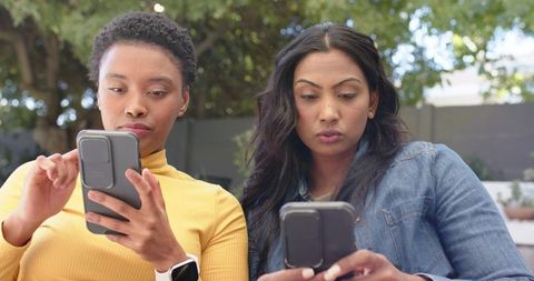 Diverse Friends Engaged with Smartphones Outdoors