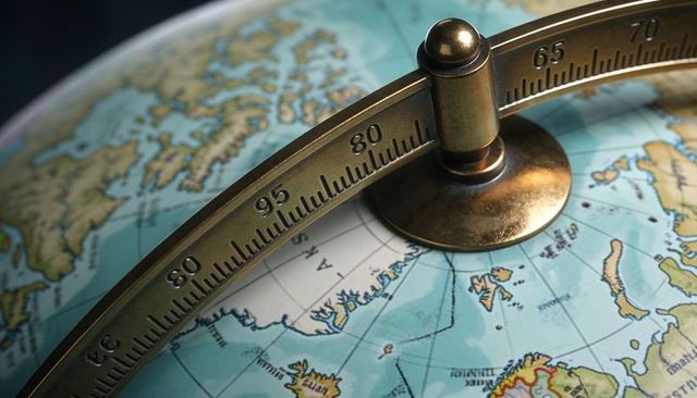 Vintage brass meridian globe closeup showing degree scale and arctic hemisphere map