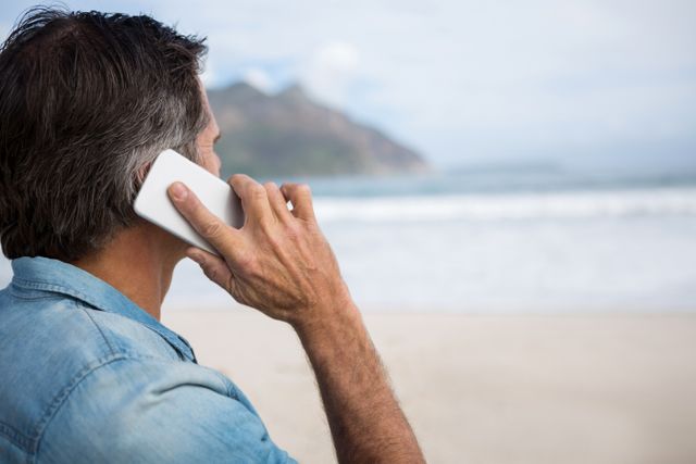 Man talking on mobile phone on beach - Download Free Stock Photos Pikwizard.com