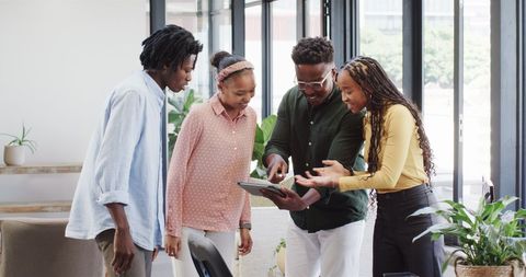 African American Team Brainstorming with Tablet in Modern Office