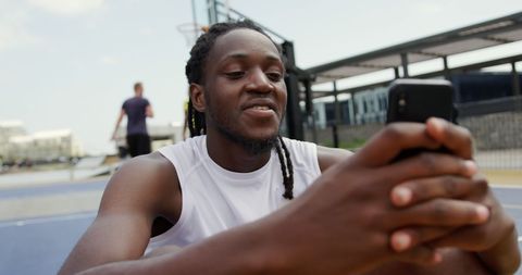 Basketball Player Engaging with Smartphone on Court - Download Free Stock Images Pikwizard.com