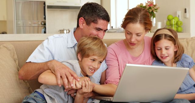 Happy Family of Four Using Laptop on Couch - Download Free Stock Images Pikwizard.com